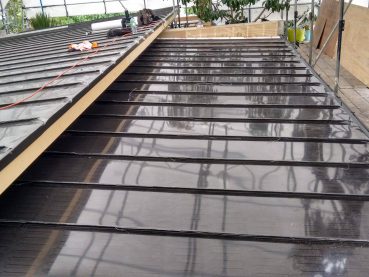 Standing seam metal roof under construction with roofing membrane on an Auckland residential project.
